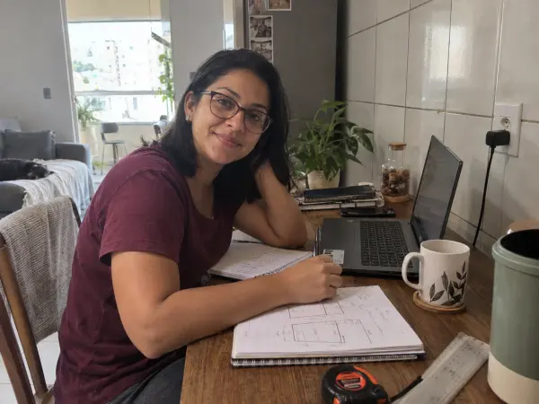 Luiza à mesa de trabalho em casa, com suas anotações.
